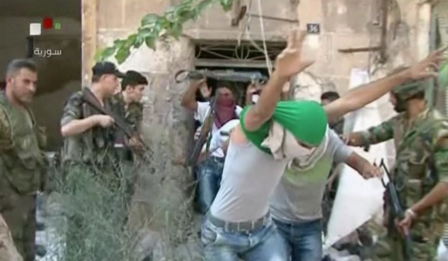 This still image from Syrian state TV video shows young men with their faces covered surrendering to government forces in Aleppo, Syria, on July 30, 2016, Syrian state media is reporting that dozens of families have started leaving besieged rebel-held neighborhoods in the northern city of Aleppo after the government opened safe corridors for civilians and fighters who want to leave. The Russian military says 169 civilians have left through the corridors since they were set up, but Syrian opposition activists say no civilians have left besieged parts of the city. (Syrian State TV via AP)