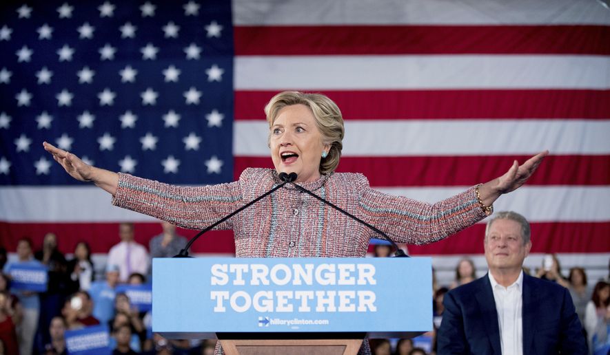 Democratic presidential candidate Hillary Clinton, accompanied by former Vice President Al Gore, right, attempts to quiet the crowd as a protester disrupts her speech during a rally at Miami Dade College in Miami, Tuesday, Oct. 11, 2016. (AP Photo/Andrew Harnik)