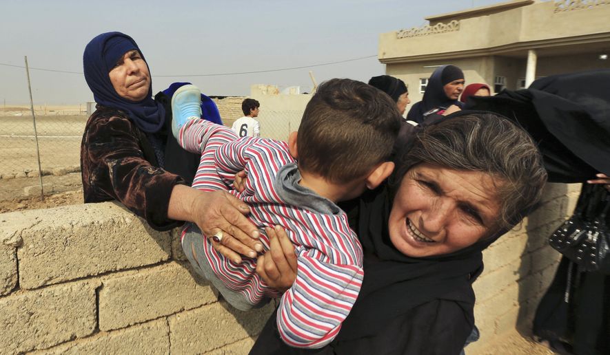 Women carry a boy over a wall as civilians flee their houses in the village of Tob Zawa, Iraq, about 9 kilometers (5.6 miles) from Mosul, Tuesday, Oct. 25, 2016, as Iraq&#39;s elite counterterrorism forces fight against Islamic State militants. (AP Photo/Khalid Mohammed)