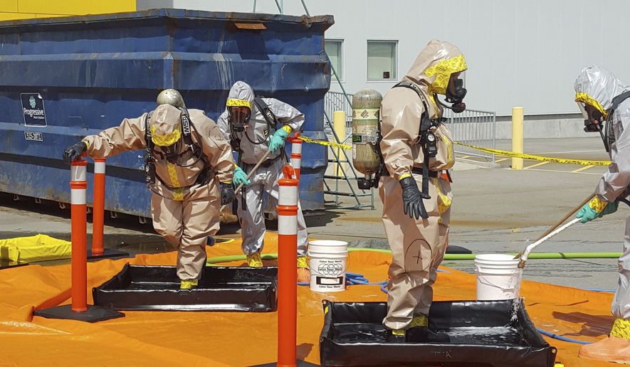 In this June 27, 2016, file photo provided by the Royal Canadian Mounted Police, members of the RCMP go through a decontamination procedure in Vancouver after intercepting a package containing approximately 1 kilogram (2.2 pounds) of the powerful opioid carfentanil imported from China. U.S. assertions that China is the top source of the synthetic opioids that have killed thousands of drug users in the U.S. and Canada are unsubstantiated, Chinese officials told the Associated Press. (Royal Canadian Mounted Police via AP, File)