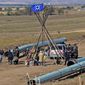 FILE- In this Oct. 10, 2016, file photo, Law enforcement officers, left, drag a person from a protest against the Dakota Access Pipeline, near the town of St. Anthony in rural Morton County, N.D. North Dakota Sen. John Hoeven said Tuesday, Jan. 31, 2017, that the Acting Secretary of the Army has directed the Army Corps of Engineers to proceed with an easement necessary to complete the Dakota Access pipeline. (Tom Stromme/The Bismarck Tribune via AP, File)