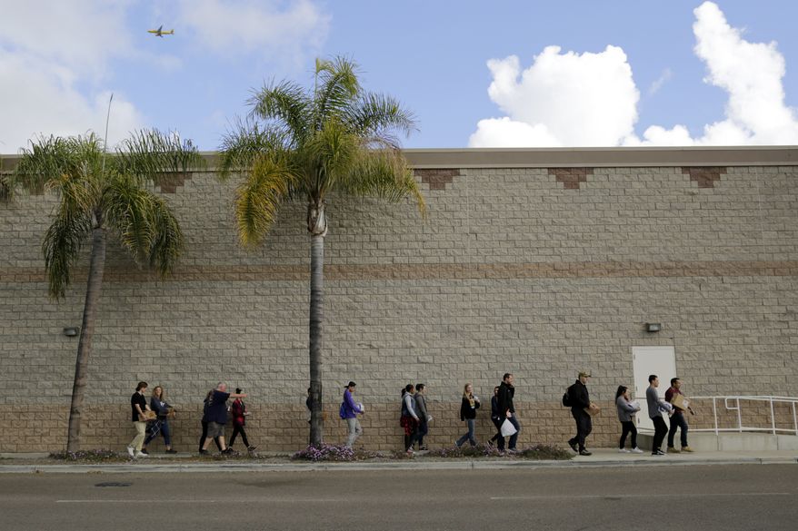 Volunteers carry donated items towards a group of undocumented migrants looking for work as day laborers alongside a hardware store Saturday, Feb. 4, 2017, in San Diego. President Donald Trump's promised crackdown on "sanctuary cities" has revealed the deep divide on immigration in liberal and conservative states, with some moving to follow his order and others breaking with the U.S. government to protect immigrants in the country illegally. (AP Photo/Gregory Bull)