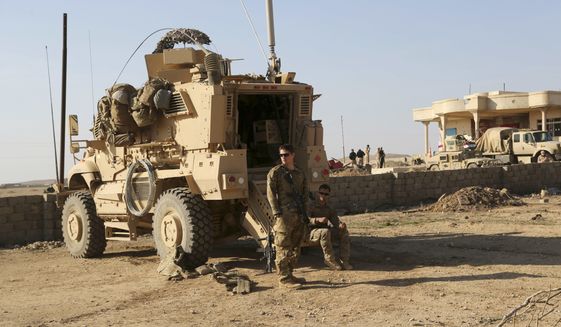 In this Thursday, Feb. 23, 2017 photo, U.S. Army soldiers stand outside their armored vehicle on a joint base with Iraqi army south of Mosul, Iraq. As Iraqi forces push into western Mosul coalition troops are closer to frontline fighting than ever before. Coalition forces have moved their bases closer to the front, relaxed their rules of engagement and during the push on Mosul airport coalition advisors were embedded with forward Iraqi rapid response and special forces units. Coalition officials say the change is helping speed up Iraqi military gains, but it marks a steady escalation of U.S. involvement in Iraq that could undermine the sustainability of Iraq&#39;s territorial victories. (AP Photo/ Khalid Mohammed)