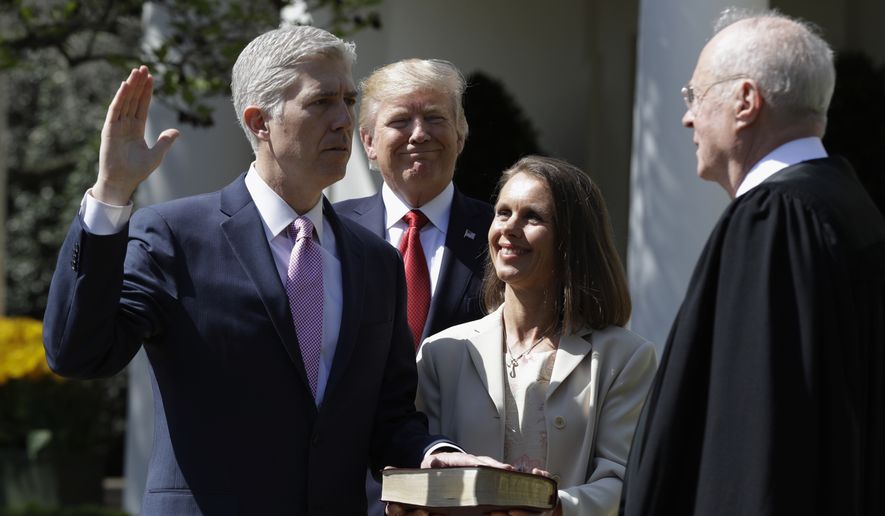 President Donald Trump watches as Supreme Court Justice Anthony Kennedy administers the judicial oath to Judge Neil Gorsuch during a re-enactment in the Rose Garden of the White House White House in Washington, Monday, April 10, 2017. Holding the bible is Gorsuch&#39;s wife Marie Louise Gorsuch. (AP Photo/Evan Vucci)