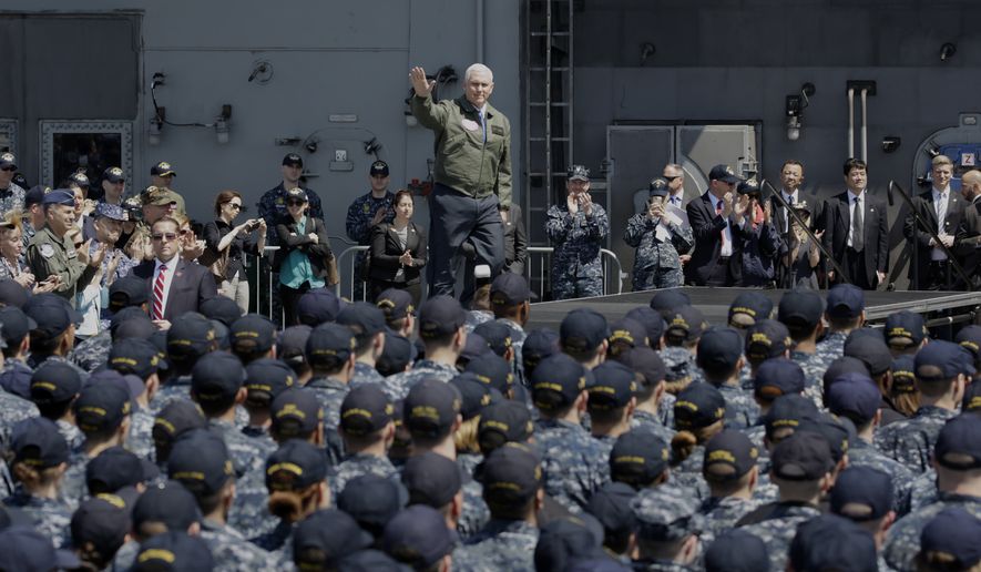 U.S. Vice President Mike Pence, center top, waves before he speaks to U.S. servicemen and Japanese Self-Defense Forces personnel on the flight deck of U.S. navy nuclear-powered aircraft carrier USS Ronald Reagan at the U.S. Navy&#39;s Yokosuka base in Yokosuka, south of Tokyo, Wednesday, April 19, 2017. (AP Photo/Eugene Hoshiko)
