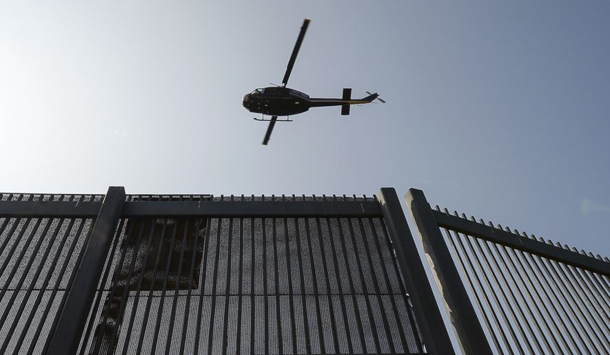In this Tuesday, May 2, 2017, photo, a Customs and Border Protection helicopter flies at a low altitude over the U.S.-Mexico border fence near the Gateway International Bridge in Brownsville, Texas. (Jason Hoekema/The Brownsville Herald via AP)