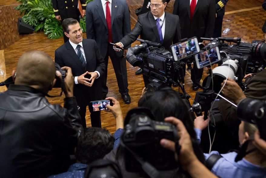 Mexico's President Enrique Pena Nieto, top left, pauses while speaking to the press, at the end of a press conference where he announced measures intended to protect journalists, in Mexico City, Wednesday, May 17, 2017. Pena said he is taking actions to halt slayings of journalists, without giving specifics, and promised more resources to help those under threat. Past measures have been ineffective in stopping the bloodshed among the country's media workers. (AP Photo/Rebecca Blackwell)