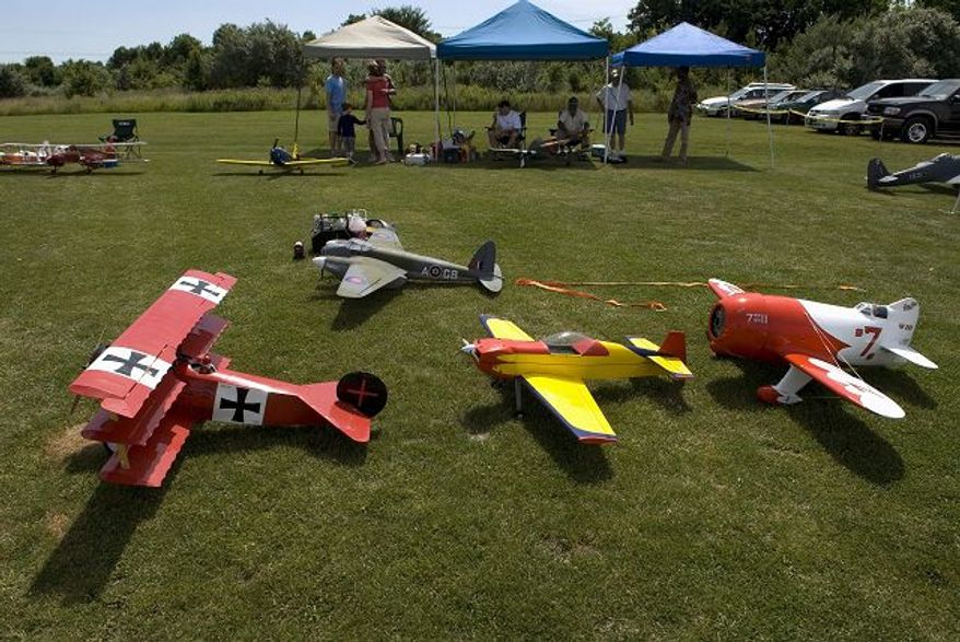 ** FILE ** Replicas of a World War I-era Fokker DR-1 triplane (left), a stunt plane, the Granville Brothers' Gee Bee racing plane and a World War II-era DeHavilland Mosquito (background) wait to take to the air as members of the Freestate Aeromodelers fly scale reproductions of historic aircraft during the third annual Airplanes of the World Scale Fly-In at Konterra Model Airpark in Laurel, Md., on Saturday, June 23, 2007. ( J.M. Eddins Jr./The Washington Times)