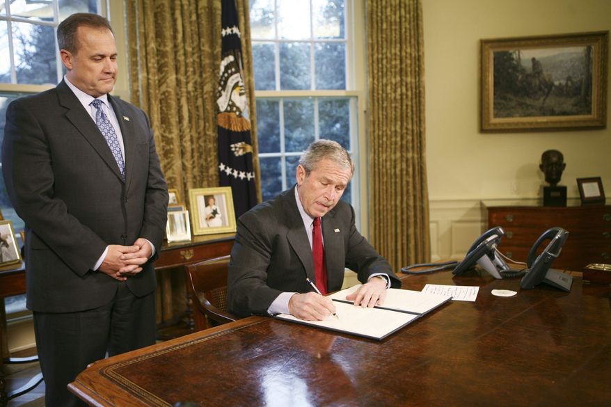 WASHINGTON - JANUARY 29: U.S. President George W. Bush signs the Executive Order Protecting American Taxpayers from Government Spending on Wasteful Earmarks as Jim Nussle, Director Office of Management and Budget, looks on in the Oval Office of the White House January 29, 2008 in Washington, DC. (Photo by Dennis Brack-Pool/Getty Images)