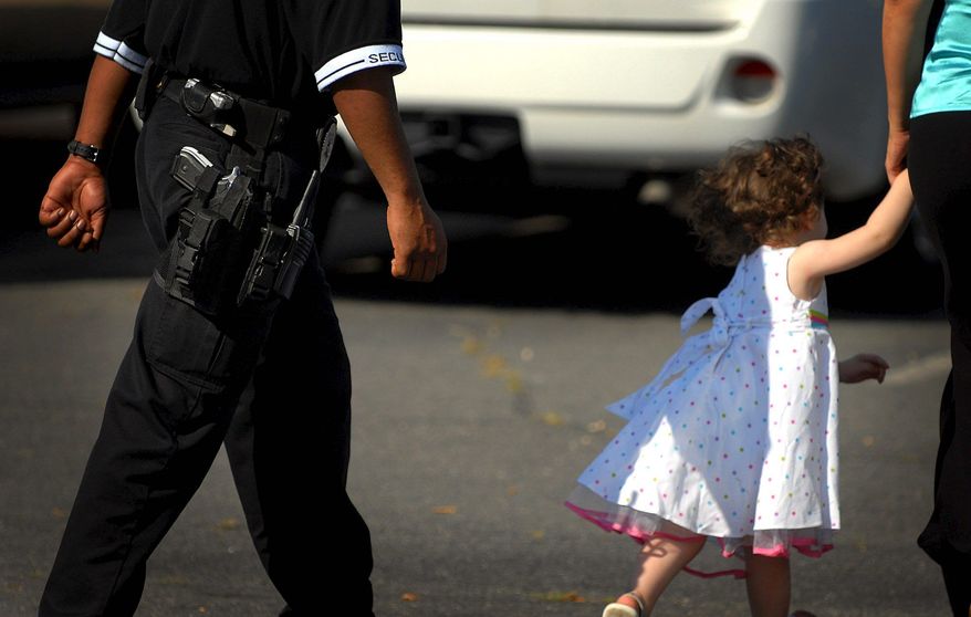 Astrid Riecken/The Washington Times
An armed guard guides visitors to the school Tuesday while monitoring the Islamic Saudi Academy grounds.