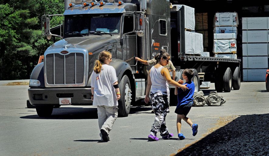 Photographs by John Tully/ The Washington Times
Mary Carter, center, walks with her children Heather, 14, and son Justin, 8, back to board the truck after a break before heading back on the road to Pennsylvania from New Hampshire. Carter and Russell will be traveling with Carter's children for a month this summer. "It's affecting money we could send home to help the kids. To put food in their stomachs and clothes on them. To give them a life," Russell said about the rising cost of diesel and having to juggle their daily expenses.