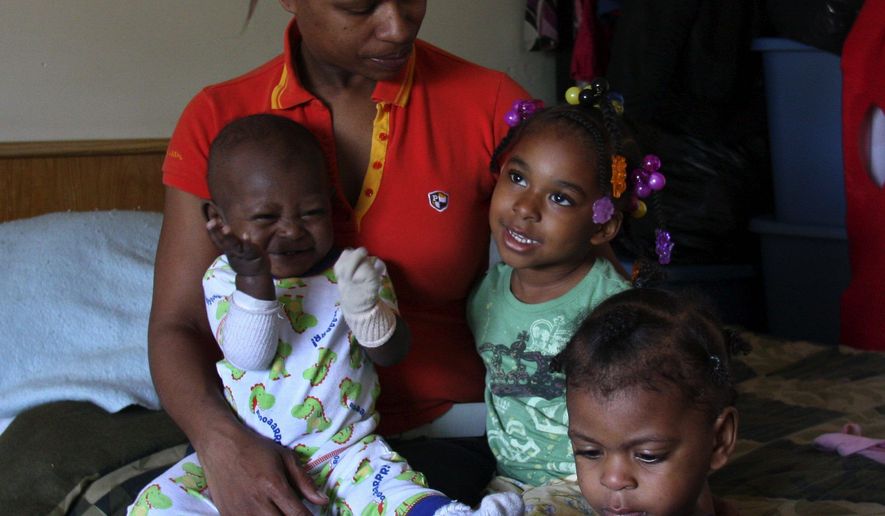 File photo — Margo Kindred, 38, with grandchildren NaZair Kindred (left), 11 months, NaZharea Kindred (center), 3, and NaZeon Kindred (right), 2, didn't find out she needed her birth certificate to apply for Michigan public assistance benefits until after she moved her family to a homeless shelter. June 26, 2008 (Associated Press)