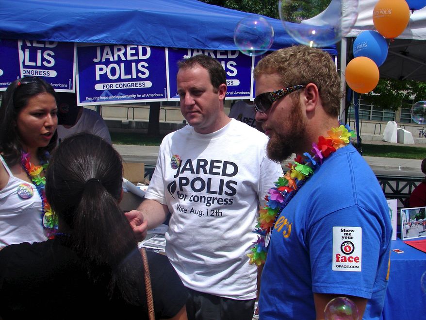 Democratic congressional candidate Jared Polis (center) discusses the issues with attendees at Denver's recent gay pride festival. Mr. Polis is running in Colorado's 2nd District. (Valerie Richardson/The Washington Times)