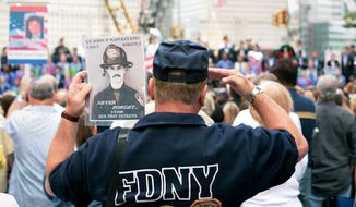 A fireman, holding the photo of 9/11 victim Lt. John P. Napolitano, FDNY, salutes near Ground Zero during the ceremony marking the seventh anniversary of the 9/11 terrorist attacks on the World Trade Center in New York on September 11, 2008.    (UPI Photo/James Estrin/POOL)