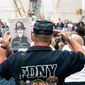 A fireman, holding the photo of 9/11 victim Lt. John P. Napolitano, FDNY, salutes near Ground Zero during the ceremony marking the seventh anniversary of the 9/11 terrorist attacks on the World Trade Center in New York on September 11, 2008.    (UPI Photo/James Estrin/POOL)