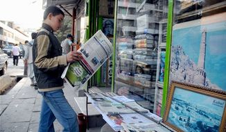 A young Afghan reads an English-language newspaper outside bookshop in Kabul. Researchers note that humanitarian crises occur most often in places where people don&#39;t speak English and that a lack of knowledge of foreign languages can affect national security. (Associated Press/File)
