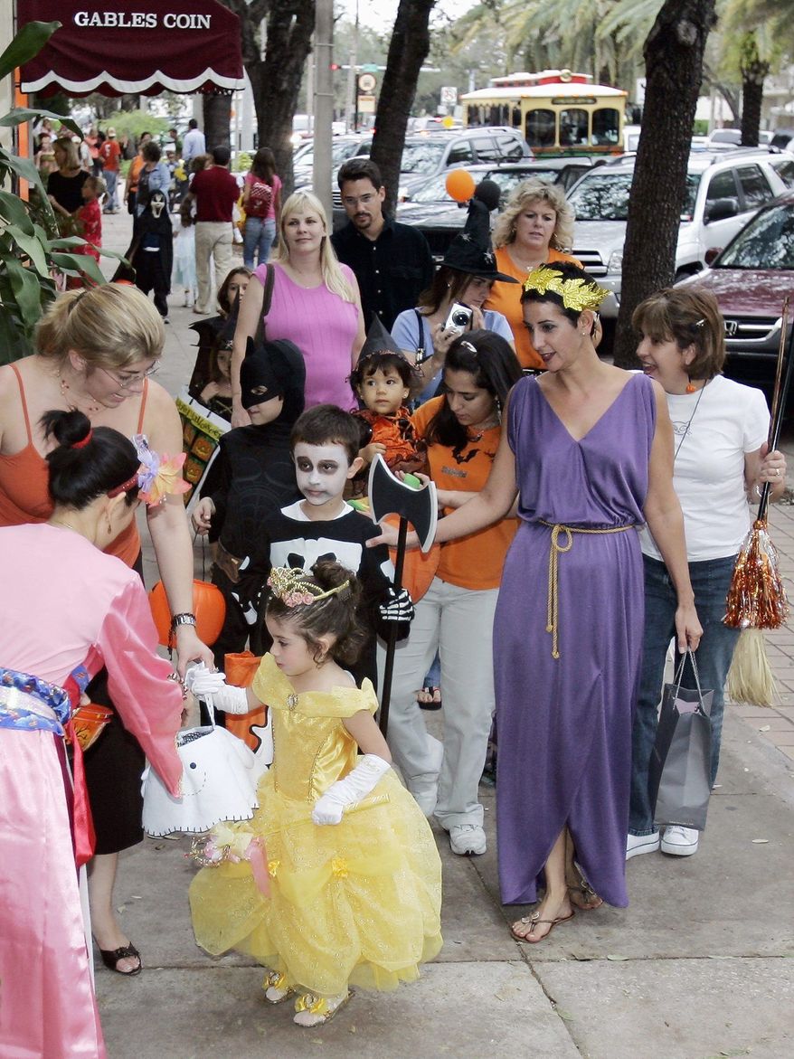 ASSOCIATED PRESS PHOTOGRAPHS
Parents take their children trick-or-treating on Miracle Mile, a business district, in Coral Gables, Fla., in this undated FILE photo.