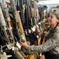 Rachel Smith, 32, of Richmond, looks over shotguns at the Bob Moates sport shop in Richmond, Va., on Thursday. Smith, the mother of five children and an avid hunter plans to purchase several guns before President-elect Obama takes office. (Associated Press)