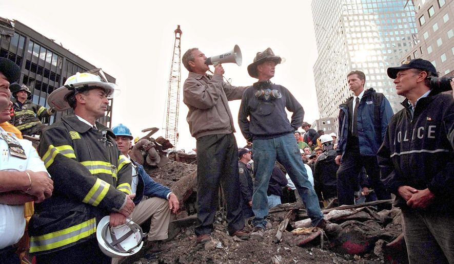 Then-President Bush speaks to rescue workers, firefighters and police officers from the rubble of ground zero in New York City three days after the attacks on Sept. 11, 2001. Retired firefighter Bob Beckwith and then-New York Gov. George Pataki join the president. (Getty Images) ** FILE **