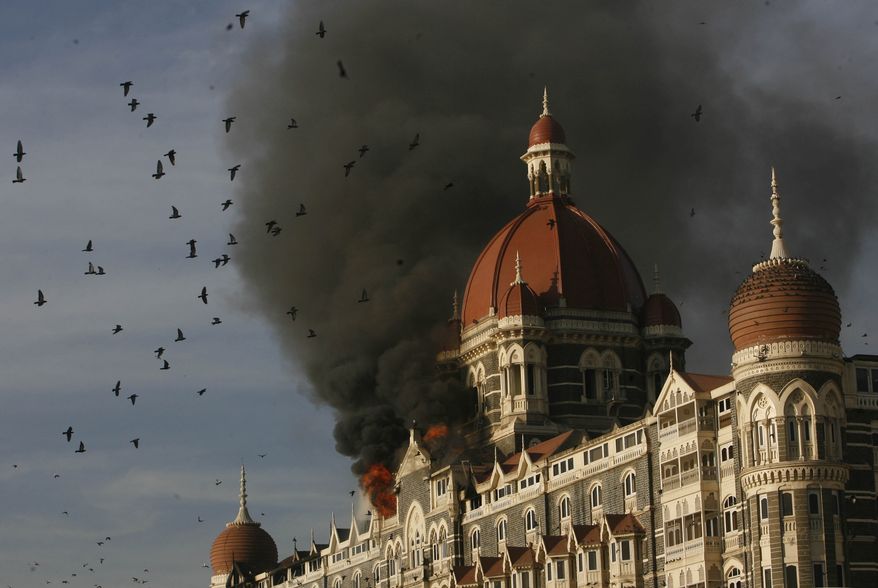 ** FILE ** Pigeons fly as the Taj Mahal Palace hotel continued to burn in Mumbai, India, on Thursday, Nov. 27, 2008. Teams of heavily armed gunmen stormed luxury hotels, a popular restaurant, hospitals and a crowded train station in coordinated attacks across India&#39;s financial capital, police said. (AP Photo) 