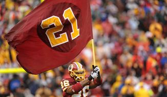 **FILE** Washington Redskins&#39; Clinton Portis carries a flag bearing the number of slain fellow player Sean Taylor as the Washington Redskins host the New York Giants at FedEx Field in Landover, Md., Sunday.
(Michael Connor / The Washington Times)
