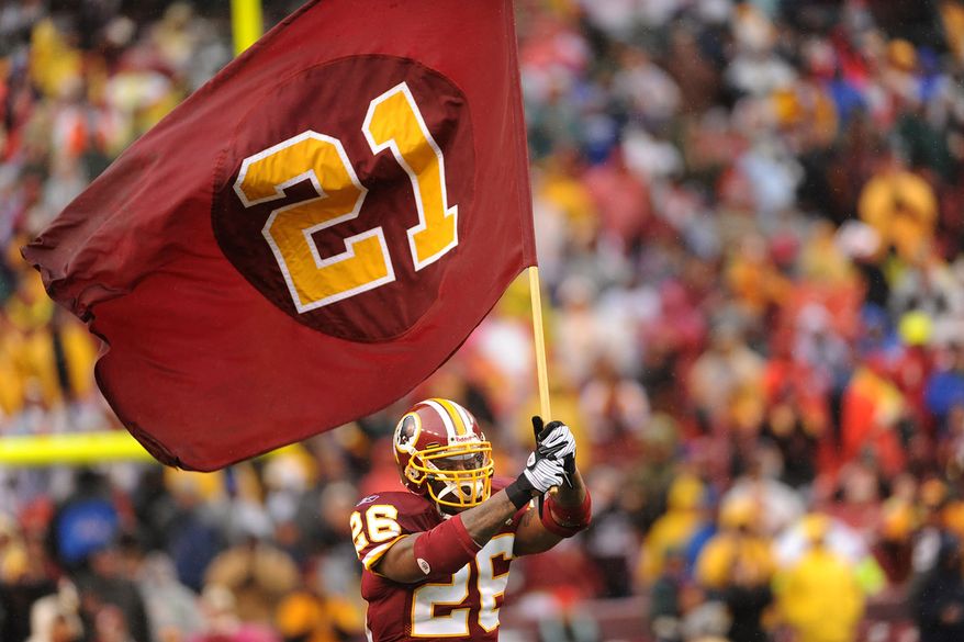 **FILE** Washington Redskins&#39; Clinton Portis carries a flag bearing the number of slain fellow player Sean Taylor as the Washington Redskins host the New York Giants at FedEx Field in Landover, Md., Sunday.
(Michael Connor / The Washington Times)