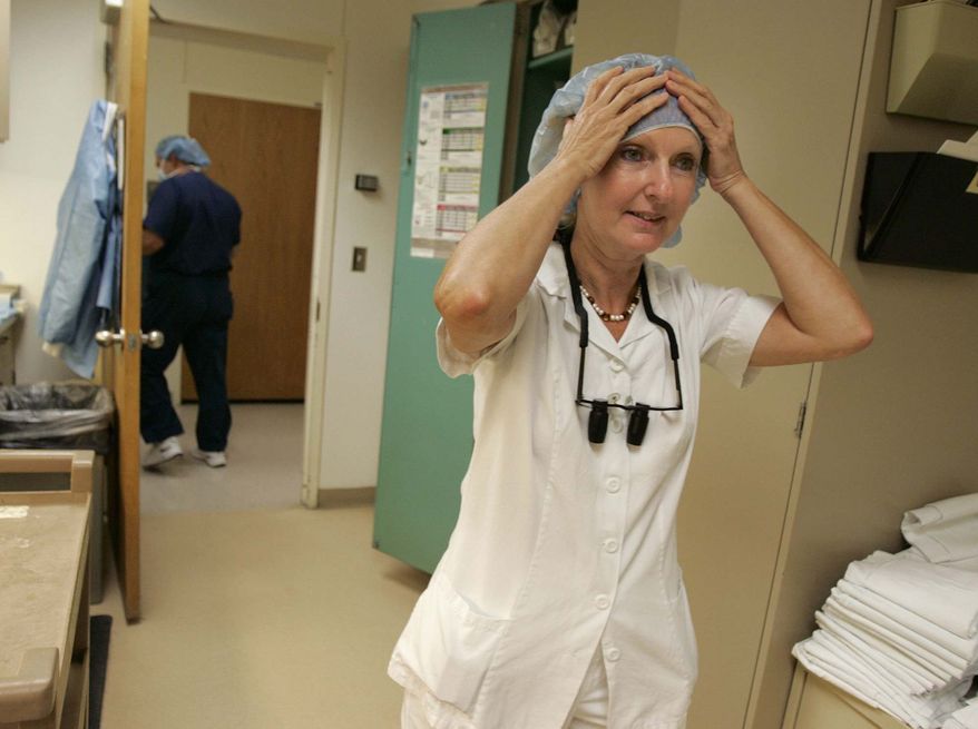 **FILE** In a Aug. 24, 2005, file photo, Reconstructive surgeon Dr. Maria Siemionow adjusts her sterile bonnet as she heads into a micro-surgical procedure at the Cleveland Clinic in Cleveland, Ohio. The Cleveland Clinic has done the nation's first almost total face transplant, a hospital spokeswoman said Tuesday, Dec.16, 2008. Dr. Maria Siemionow replaced 80 percent of a woman's face with that of a dead female donor. The hospital spokeswoman said that the operation was done a couple weeks ago.