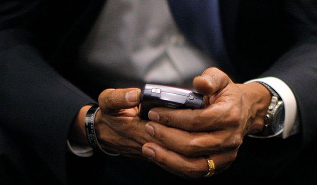 ** FILE ** Then President-elect Barack Obama checks his BlackBerry in St. Louis. 