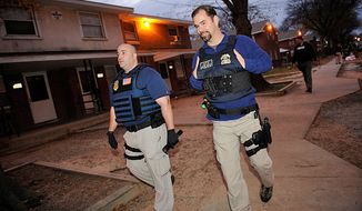 Special agents David Stone (left) and Darrell Bonzano with the Bureau of Alcohol, Tobacco, Firearms and Explosives walk the beat on a street in the Fairfield Court neighborhood of Richmond during a routine patrol of a Violent Crime Impact Team last month. (Barbara L. Salisbury / The Washington Times)