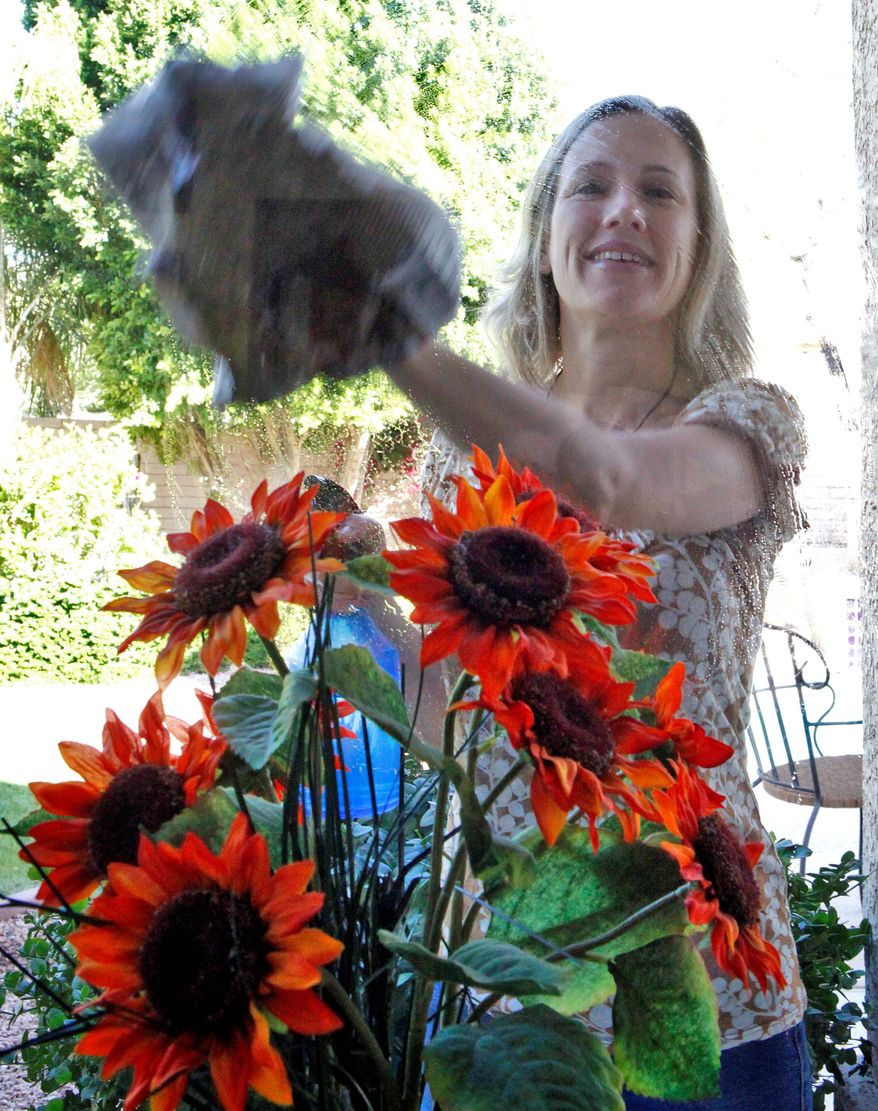 ASSOCIATED PRESS PHOTOGRAPHS
Wendy Brooks cleans her windows with vinegar and newspapers at her home in Phoenix. As many Americans curtail their spending, the multibillion-dollar green products market, which has seen rapid growth during the past few years, is expected to lose momentum, analysts say.