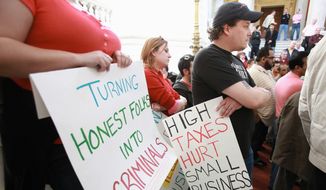 Wholesale cigarette distributor Phil Sealey (right) of Cumberland, R.I., participates in a rally to protest increased cigarette taxes outside the State House in Providence, R.I., March 31. (Associated Press)