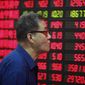 An investor looks at the stock price monitor at a private securities company in Shanghai. (AP Photo)