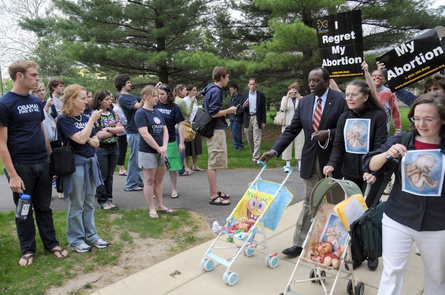 **FILE** In this photo taken May 8, 2009, anti-abortion protestors led by Alan Keyes cross the path of pro-Obama Notre Dame students in South Bend, Ind. (Associated Press)