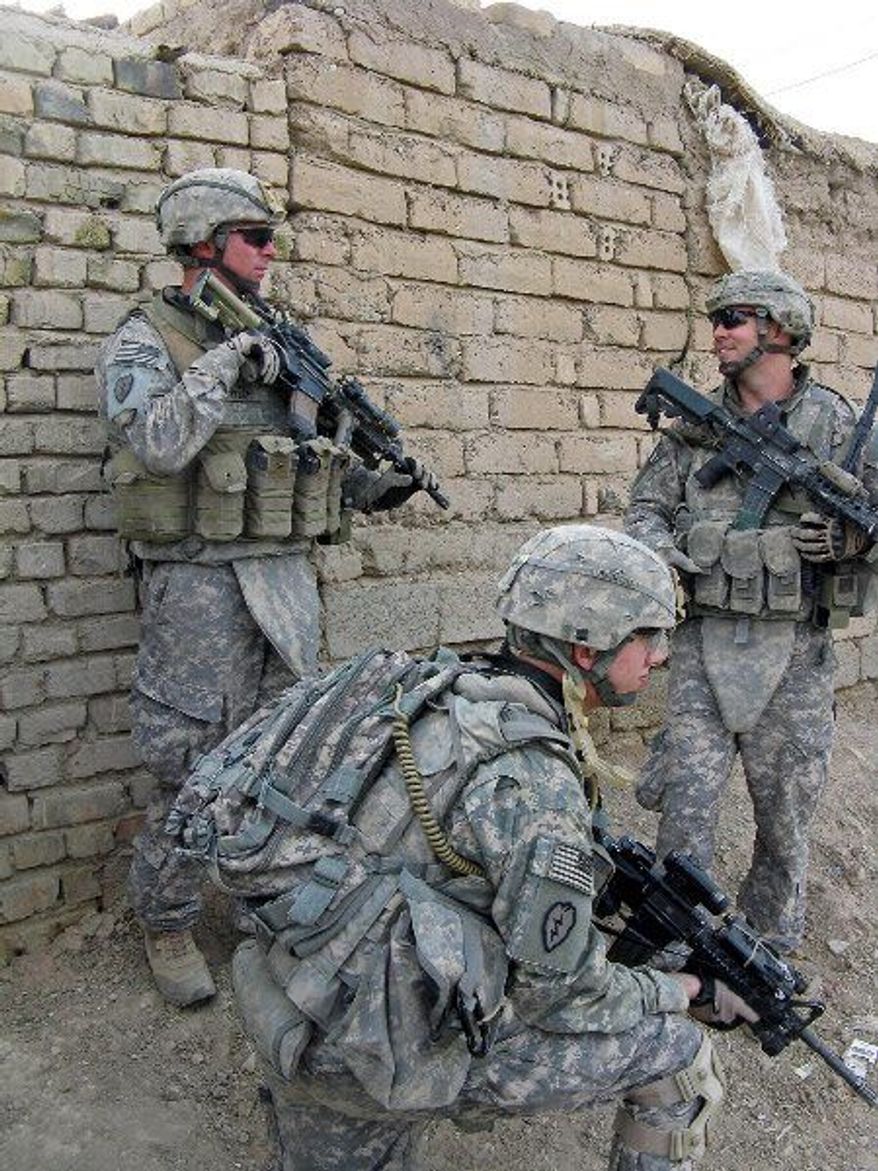 RICHARD TOMKINS/THE WASHINGTON TIMES
Iraqi and U.S. soldiers inventory a small cache of rifles and ammunition found hidden in a village house outside the town of Muqdadiya in the volatile Diyala province.
