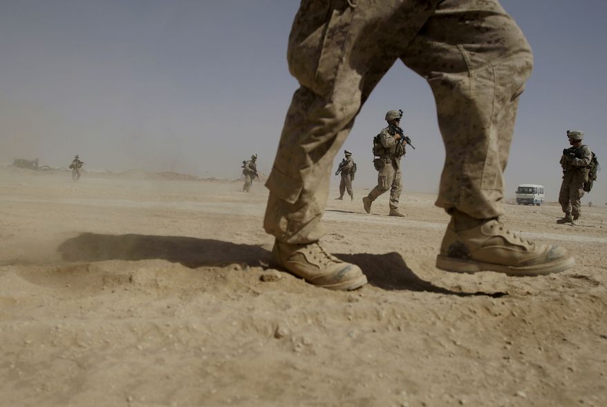 **FILE** U.S. Marines from the 2nd Marine Expeditionary Battalion walk through the sand inside Camp Leatherneck in Afghanistan's Helmand province on June 8, 2009. (Associated Press)