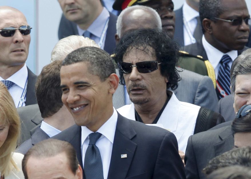 President Barack Obama, left, is followed by Libyan leader Moammar Gadhafi before a group photo at the G-8 Summit in L'Aquila, Italy, Friday, July 10, 2009. (AP Photo/Charles Dharapak)
