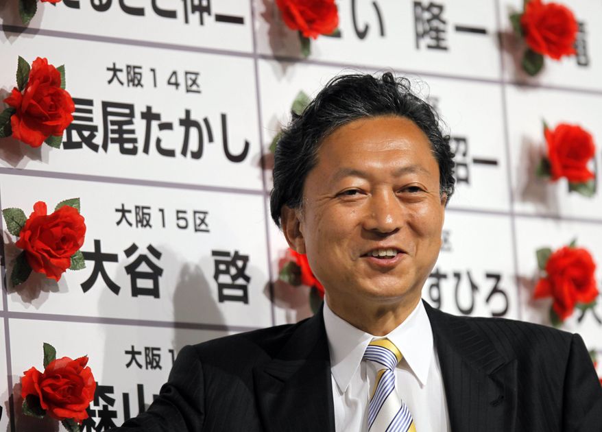 Yukio Hatoyama, leader of the Democratic Party of Japan, the country's main opposition party, smiles surrounded by red rosettes attached on victorious candidates' names during the ballot counting for the parliamentary elections at the party's election center in Tokyo on Sunday, Aug. 30, 2009. The DPJ was set to win more than 300 of the 480 seats in the lower house of parliament, ousting the Liberal Democrats, who have governed Japan for all but 11 months since 1955, according to projections by all major Japanese TV networks. (AP Photo/Itsuo Inouye)