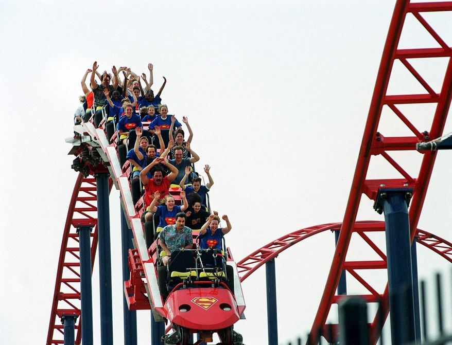 ** FILE ** Riders on the maiden voyage of Six Flags' brand-new roller coaster, Superman — Ride of Steel, round the final stretch on Thursday morning, May 18, 2000, in Largo. The coaster's tracks are a mile long, with the highest drop of 197 feet at a 70-degree angle. (The Washington Times)