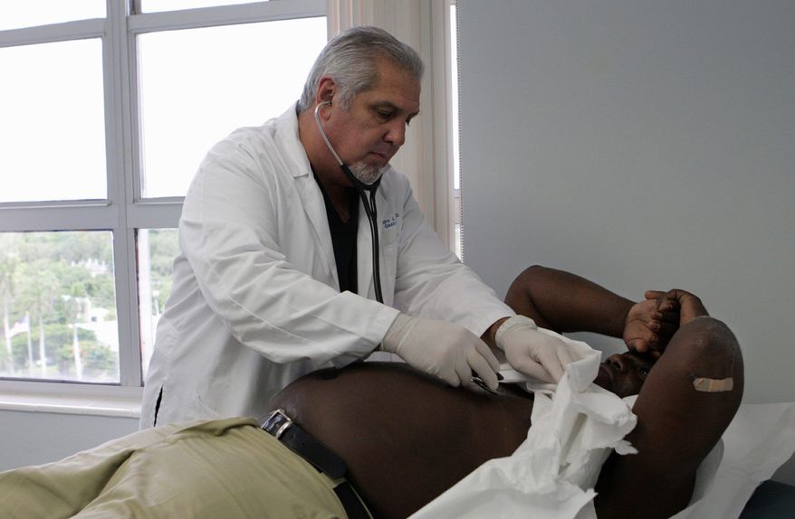** FILE ** Dr. Pedro Jose Greer examines Medicaid patient Kenneth Caldwell, 50, in his office at Mercy Hospital in Miami, where the gastroenterologist has made a career of offering treatment without regard to a patient's ability to pay. (AP Photo)