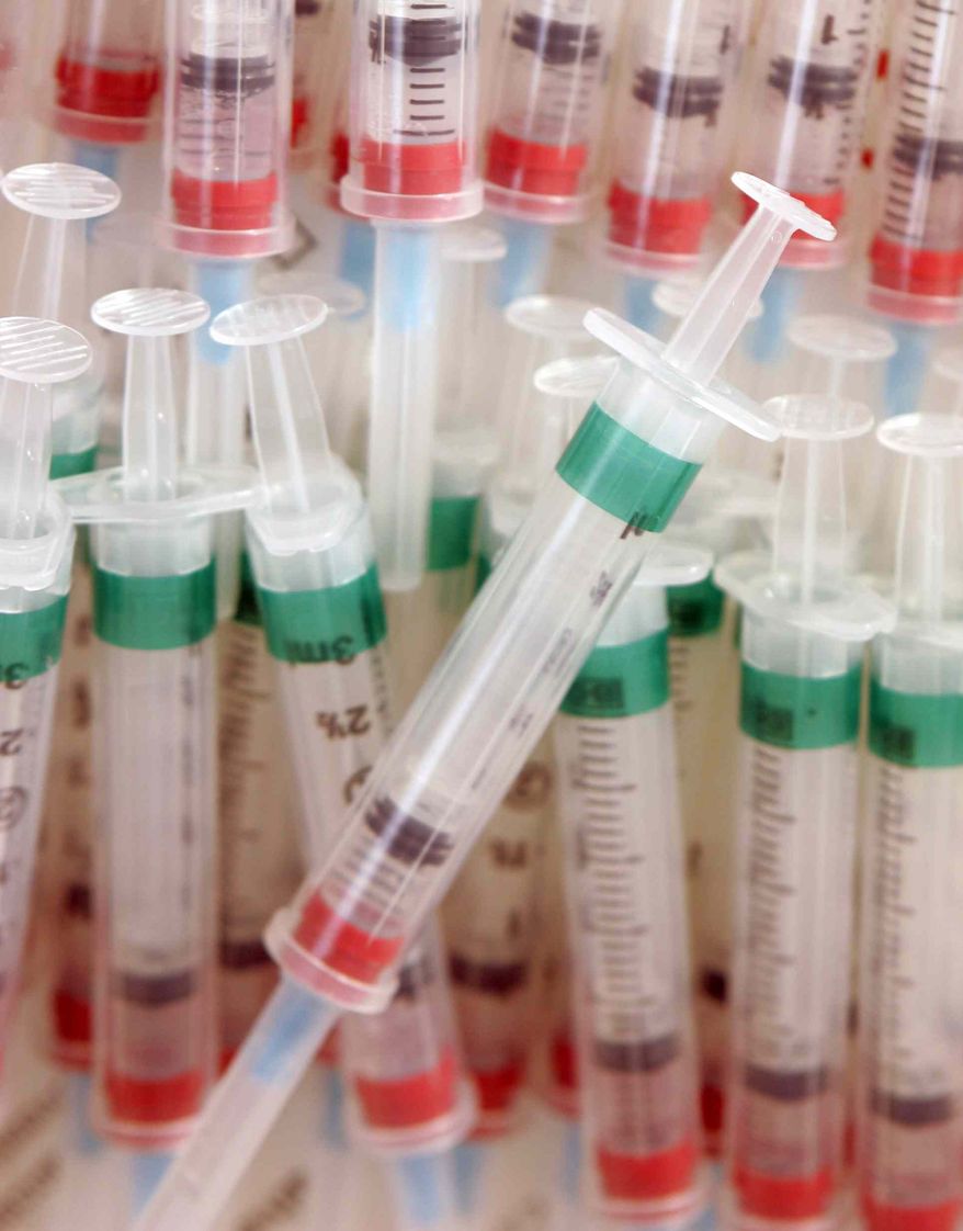 ** FILE ** Syringes filled with an influenza vaccine are piled in a container at Rocky Mountain Primary Care's Thornton, Colo., location, in this, Oct. 26, 2006, file photo. (AP Photo/Jack Dempsey, File)
