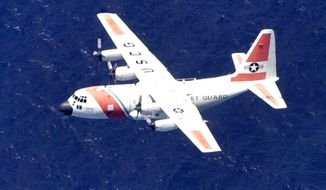 **FILE** In this August 2, 2003 photo, a U.S. Coast Guard C-130 aircraft flies over the waters off the southwest coast of Eleuthera in the Bahamas. (Associated Press)
