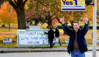 In this Nov. 4, 2009 photo, Joseph Skinner urges passing motorists to support Question 1 on the Maine ballot, which would repeal a lawmaker-passed law legalizing gay marriage. Gay marriage supporters Ann DiMella and Suzanne Blackburn post their own sign urging people to reject the referendum. (Associated Press/File)