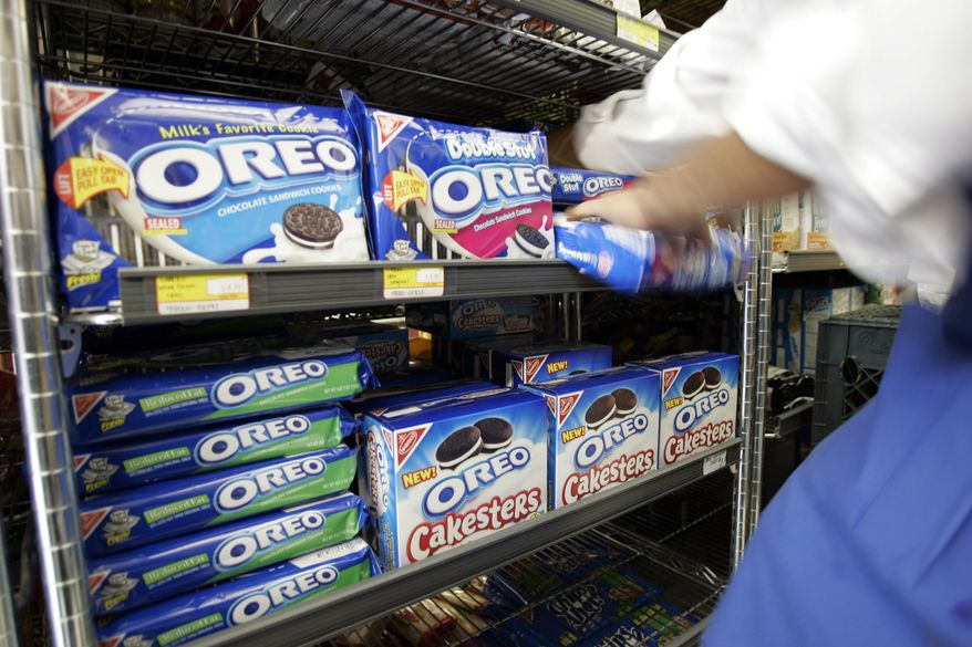 FILE - A worker fixes the display of Kraft Food's Oreo cookies at a Market in Palo Alto, Calif., in this file photo dated Monday, July 28, 2008. Shares in British chocolate maker Cadbury PLC edged higher on Monday Nov. 9, 2009, as a deadline loomed for Kraft Foods Inc. to make a formal takeover offer for the candy maker, or under British takeover rules Kraft will be prohibited from making a new offer for six months. Cadbury has already spurned a $16.7 billion cash-and-stock offer from Kraft. (AP Photo/Paul Sakuma, FILE)