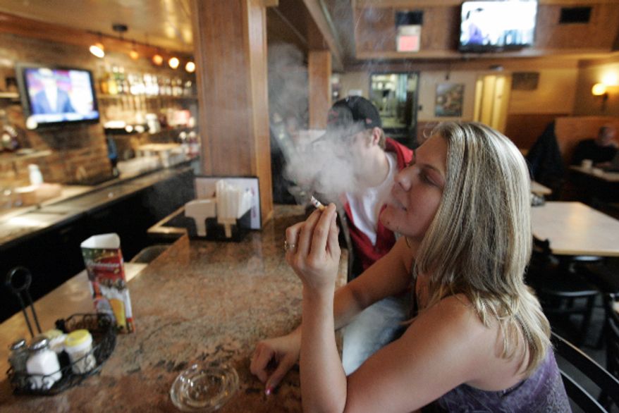 ** FILE ** Third Street Diner employee Jessica Prignano takes a smoke break at the bar in the diner in Richmond in November 2009. (AP Photo/Steve Helber, File)