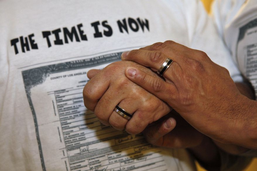 **FILE** In this photo from Oct. 6, 2009, Ed Grandis (left) and Juan D. Rondon hold hands after a bill allowing same-sex marriage in the District of Columbia was introduced at a city council meeting in Washington. (Associated Press)