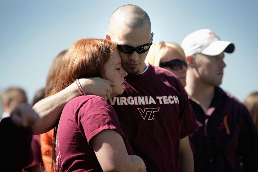 **FILE** Attendees observe the anniversary of the Virginia Tech shootings on April 16, 2008, that a year earlier took the lives of 33 faculty and students. (The Washington Times)