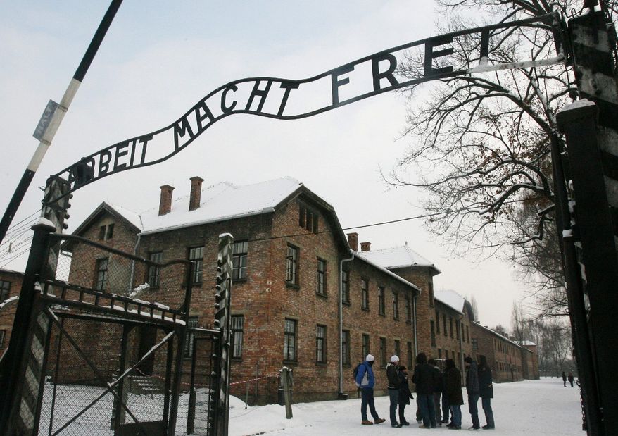 ASSOCIATED PRESS PHOTOGRAPHS
Tourists pause near the former Nazi death camp Auschwitz-Birkenau in Oswiecim, Poland, where the infamous iron sign reading "Work Sets You Free" was stolen before dawn on Friday.