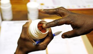 Nomvula Tshabalala (above), a hospital pharmacist, holds HIV medication while explaining proper dosage to a patient in Pretoria, South Africa, in 2009.