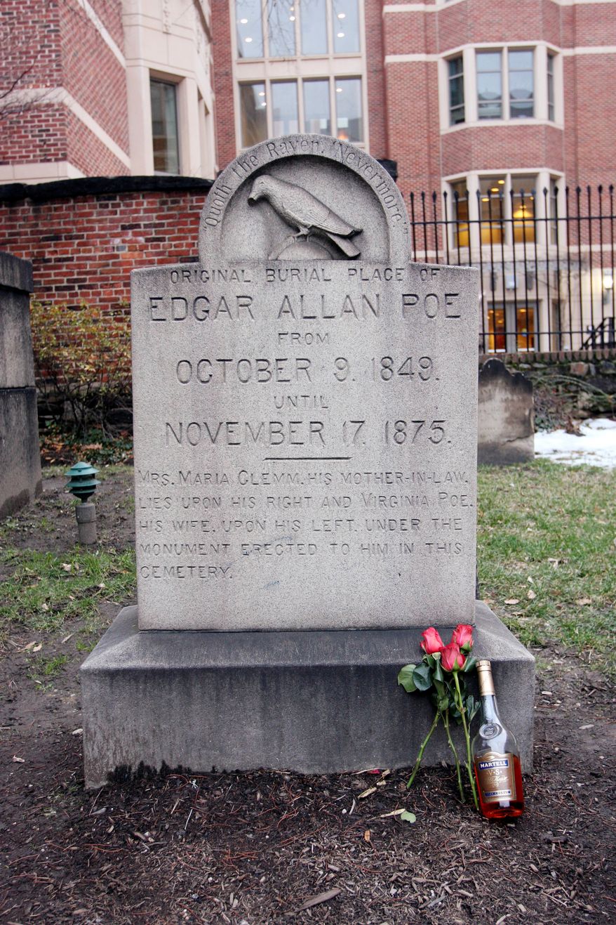 ** FILE ** The original grave of Edgar Allen Poe in Baltimore is shown with a bottle of cognac and roses left by a mysterious visitor on Saturday, Jan. 19, 2008. (AP Photo/Rob Carr, File)