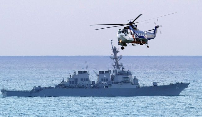 A Lebanese army helicopter flies past the USS Ramage on Tuesday as search efforts continue following the crash of an Ethiopian Airlines plane into the sea off Beirut. (AP Photo/Ben Curtis)